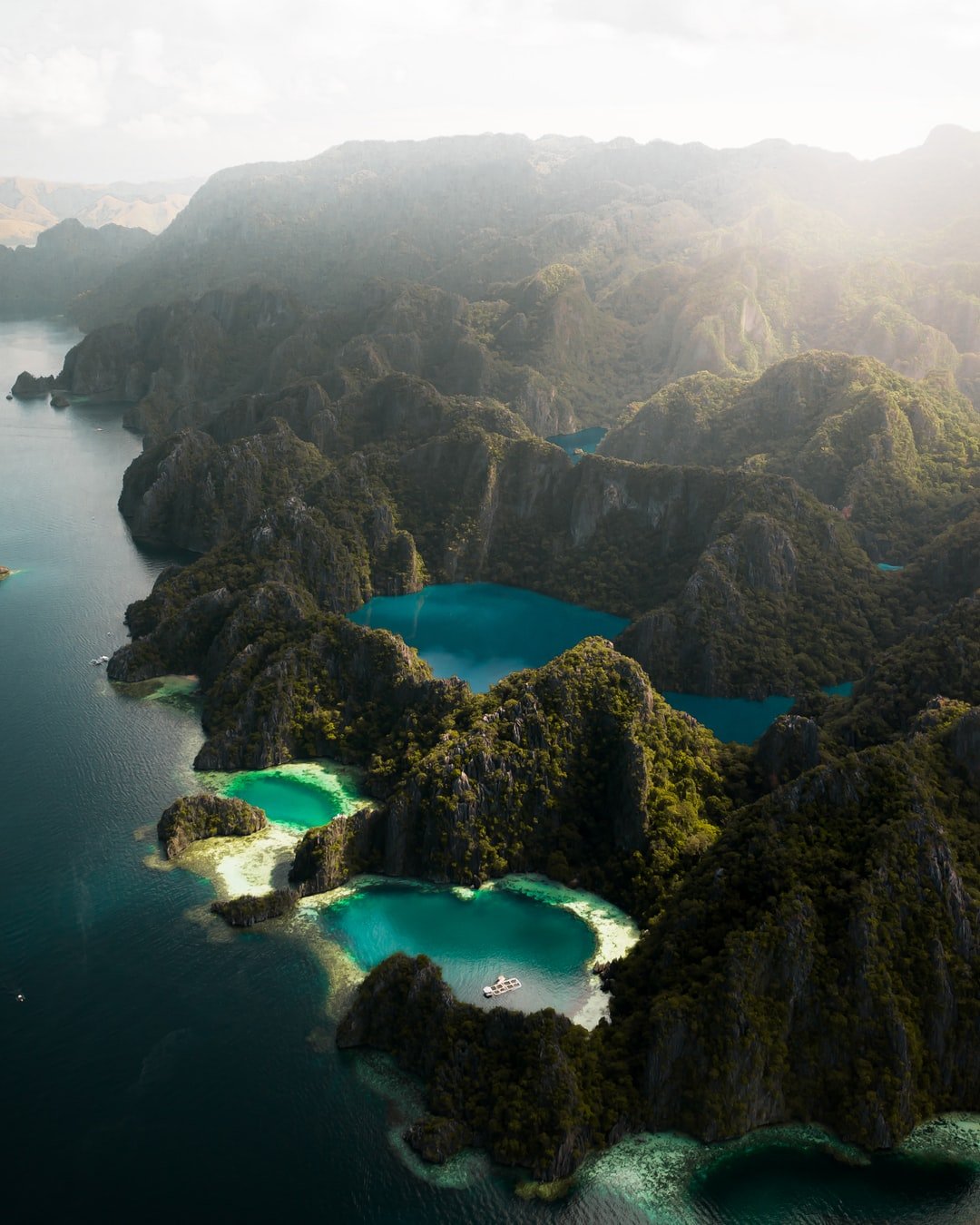 Morning light bursting through the misty clouds over Barracuda Lake - Coron Island, Palawan Province, Philippines.  | Palawan in Philippines