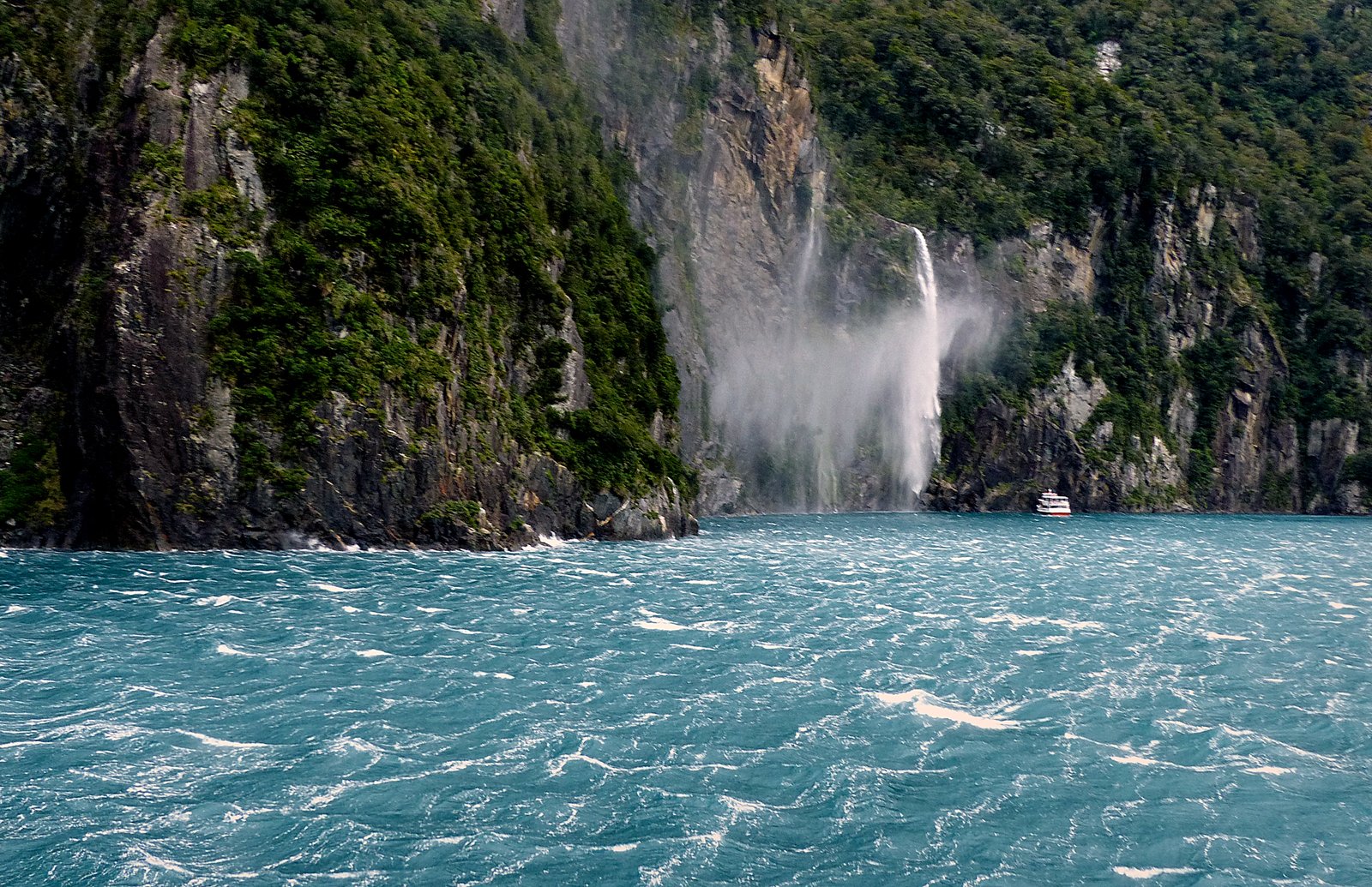 Described by Rudyard Kipling as the 'eighth wonder of the world', Milford Sound was carved by glaciers during the ice ages. Milford Sound is breathtaking in any weather. The fiord's cliffs rise vertically from the dark waters, mountain peaks scrape the sky and waterfalls cascade downwards, some as high as 1000 metres. When it rains in Milford Sound, and it often does, those waterfalls multiply with magnificent effect. | Milford Sound in New Zealand